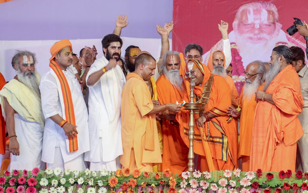 Ayodhya: Uttar Pradesh Chief Minister Yogi Adityanath lights the lamp during a function to celebrate the 80th birthday of Ram Janam Bhoomi Trust President Nritya Gopal Das, in Ayodhya on Monday, June 25, 2018. (PTI Photo) (PTI6_25_2018_000190B)