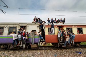 EDS PLS TAKE NOTE OF THIS PTI PICK OF THE DAY::::::::: Ghaziabad: Commuters hang on the gates and sit on the roof while traveling by a crowded train on World Population Day, at Noli Railway Station near Ghaziabad on Wednesday, July 11, 2018. The theme of World Population Day 2018 is ''Family planning is a human right'. (PTI Photo/Manvender Vashist) (PTI7_11_2018_000053A)(PTI7_11_2018_000186B)