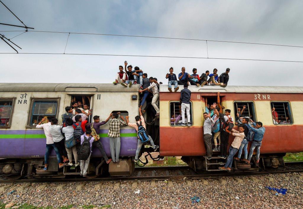 EDS PLS TAKE NOTE OF THIS PTI PICK OF THE DAY::::::::: Ghaziabad: Commuters hang on the gates and sit on the roof while traveling by a crowded train on World Population Day, at Noli Railway Station near Ghaziabad on Wednesday, July 11, 2018. The theme of World Population Day 2018 is ''Family planning is a human right'. (PTI Photo/Manvender Vashist) (PTI7_11_2018_000053A)(PTI7_11_2018_000186B)