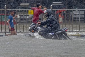 Mumbai: A motorcyclist moves through a waterlooged road during heavy rains, at King Circle in Mumbai on Tuesday, July 10, 2018. (PTI Photo/Shashank Parade) (PTI7_10_2018_000103B)
