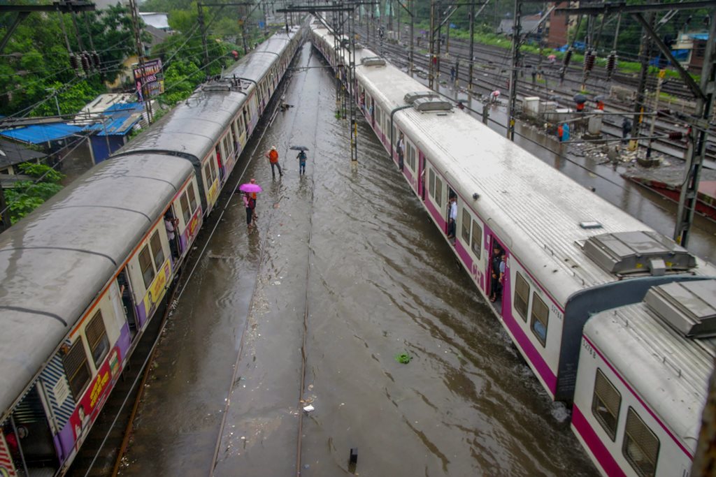 Thane: Suburban trains chug on water-logged tracks during heavy rainfall, in Mumbai on Monday, July 09, 2018. (PTI Photo) (PTI7_9_2018_000178B)