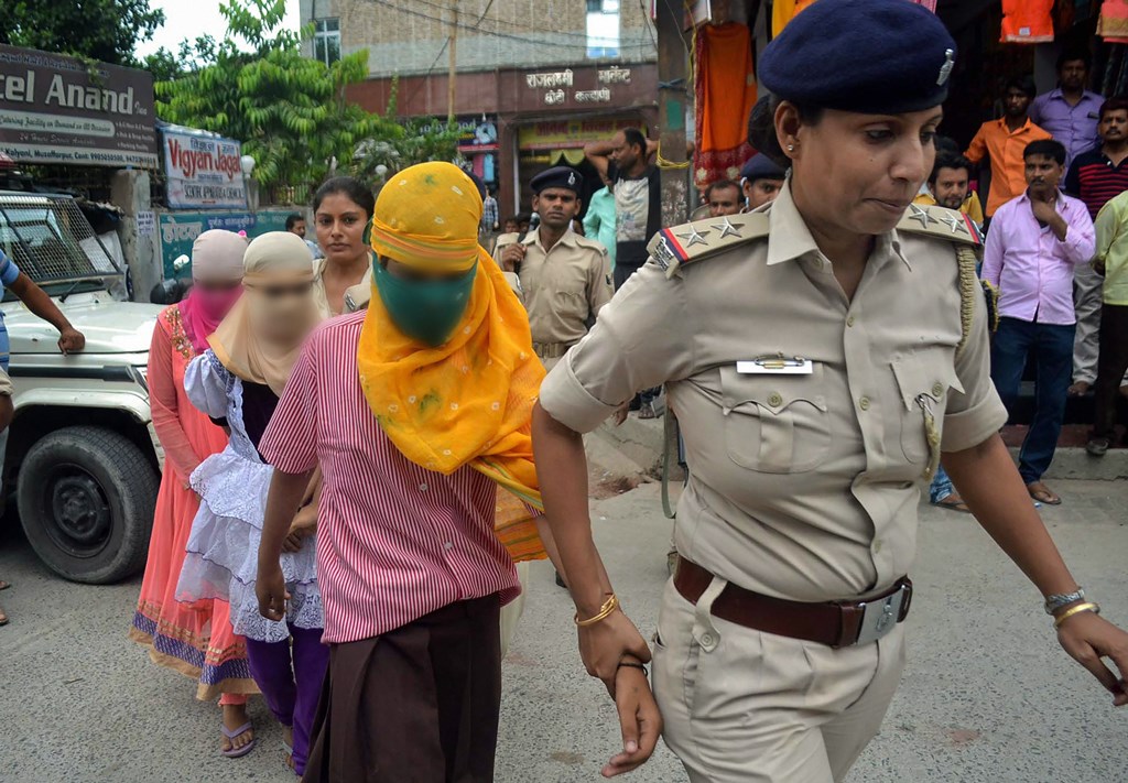 Muzaffarpur: Police personnel escort children out of a government-funded shelter, in Muzaffarpur, on Monday, July 23, 2018. A girl of a government shelter home has alleged that one of her fellow inmates was beaten to death and buried at the premises of the facility, and several were raped. (PTI Photo)(PTI7_23_2018_000192B)