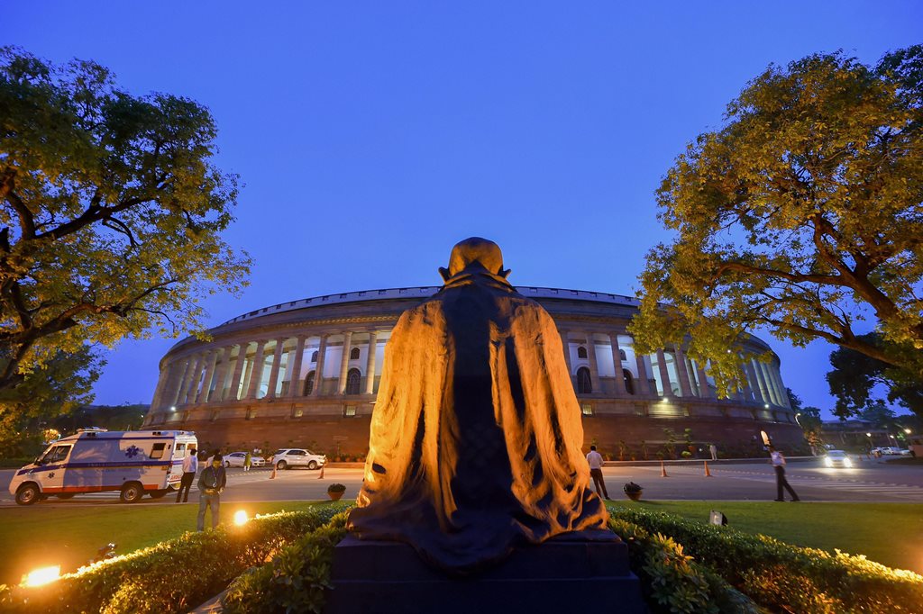 New Delhi: The statue of Mahatma Gandhi in the backdrop of the Parliament House during the Monsoon Session, in New Delhi on Friday, July 20, 2018. (PTI Photo/Kamal Kishore) (PTI7_20_2018_000250B)