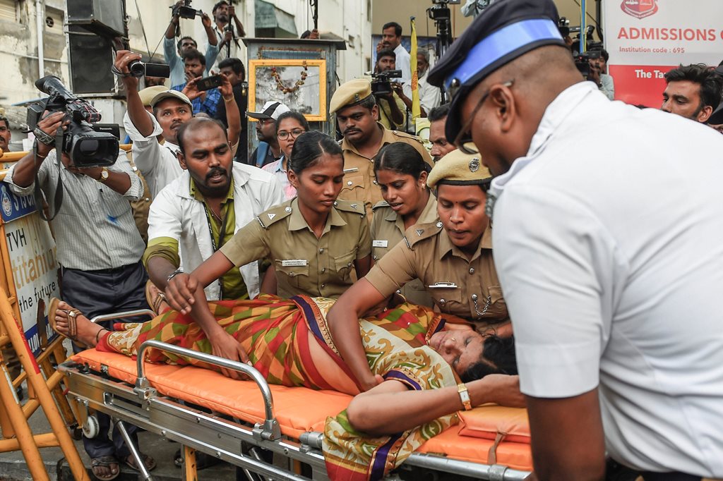 Chennai: A Dravida Munnetra Kazhagam (DMK) supporter being taken for treatment after she fainted outside the hospital, where DMK chief M Karunanidhi is being treated, in Chennai on Monday, July 30, 2018. (PTI Photo) (PTI7_30_2018_000218B)