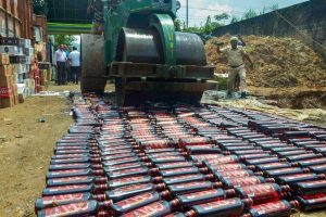 Guwahati: A road-roller is used to crush the liquor bottles seized by excise department sleuths, in Guwahati on Friday, Aug 10, 2018. (PTI Photo) (PTI8_10_2018_000130B)