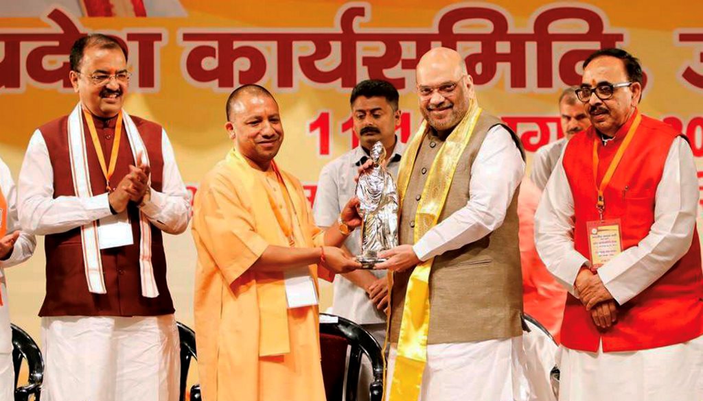 Meerut: BJP President Amit Shah is welcomed by UP Chief Minister Yogi Adityanath at the BJP's State Working Committee Meeting, in Meerut on Sunday, August 12, 2018. (Twitter Photo via PTI)(PTI8_12_2018_000150B)
