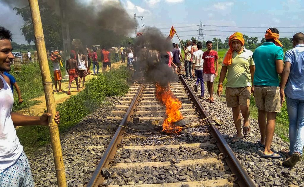 Patna: Swarn Sena activist burn tyres on the railway tracks to stop trains during their Bharat bandh, called to press for reservation, in Patna, Thursday, Sept 6, 2018. (PTI Photo) (PTI9_6_2018_000081B)