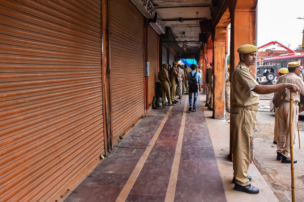 Jaipur: Police personnel guard outside closed shops during the Bharat Bandh, called by the upper-caste organisations in protest over the recent amendment of the SC/ST Act, in Jaipur, Thursday, Sept 6, 2018. (PTI Photo) (PTI9_6_2018_000095B)