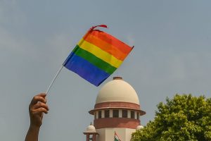New Delhi: An activist waves a rainbow flag (LGBT pride flag) after the Supreme Court verdict which decriminalises consensual gay sex, outside the Supreme Court in New Delhi, Thursday, Sept 6, 2018. A five-judge constitution bench of the Supreme Court today, unanimously decriminalised part of the 158-year-old colonial law under Section 377 of the IPC which criminalises consensual unnatural sex, saying it violated the rights to equality. (PTI Photo/Kamal Kishore) (PTI9_6_2018_000133B)