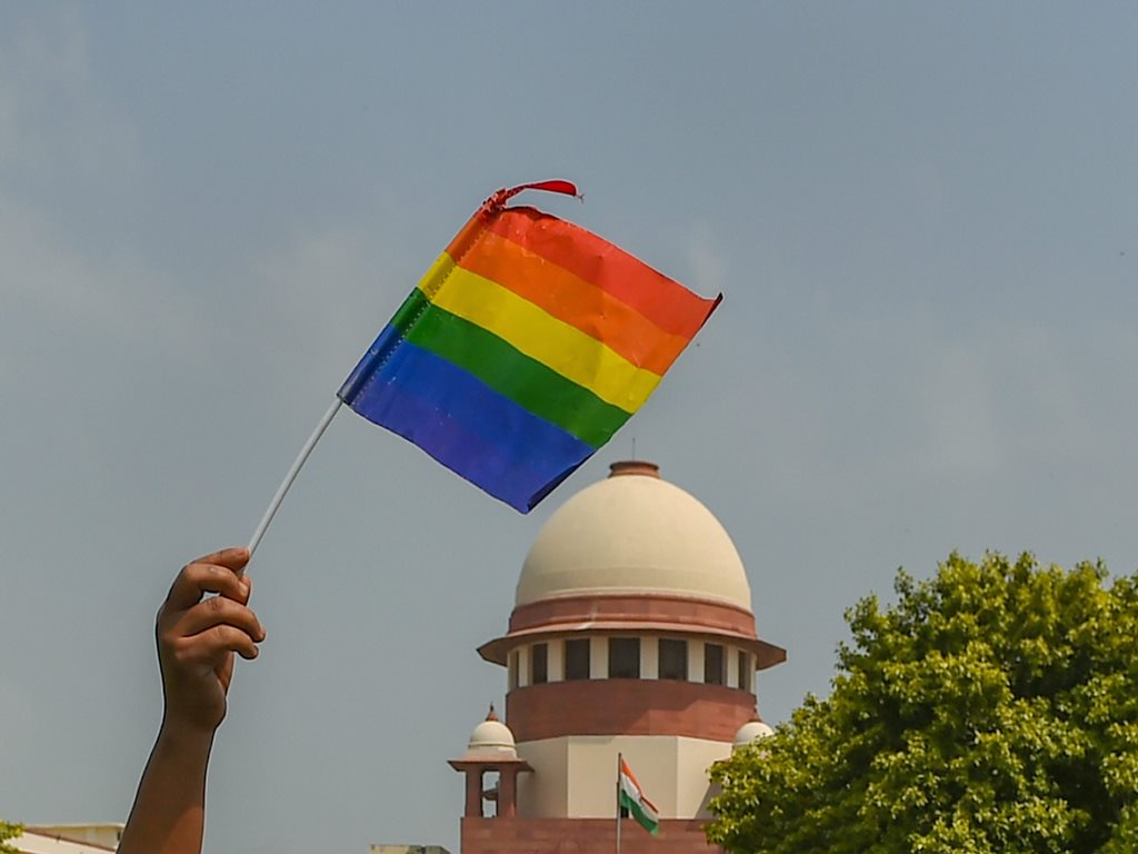 New Delhi: An activist waves a rainbow flag (LGBT pride flag) after the Supreme Court verdict which decriminalises consensual gay sex, outside the Supreme Court in New Delhi, Thursday, Sept 6, 2018. A five-judge constitution bench of the Supreme Court today, unanimously decriminalised part of the 158-year-old colonial law under Section 377 of the IPC which criminalises consensual unnatural sex, saying it violated the rights to equality. (PTI Photo/Kamal Kishore) (PTI9_6_2018_000133B)