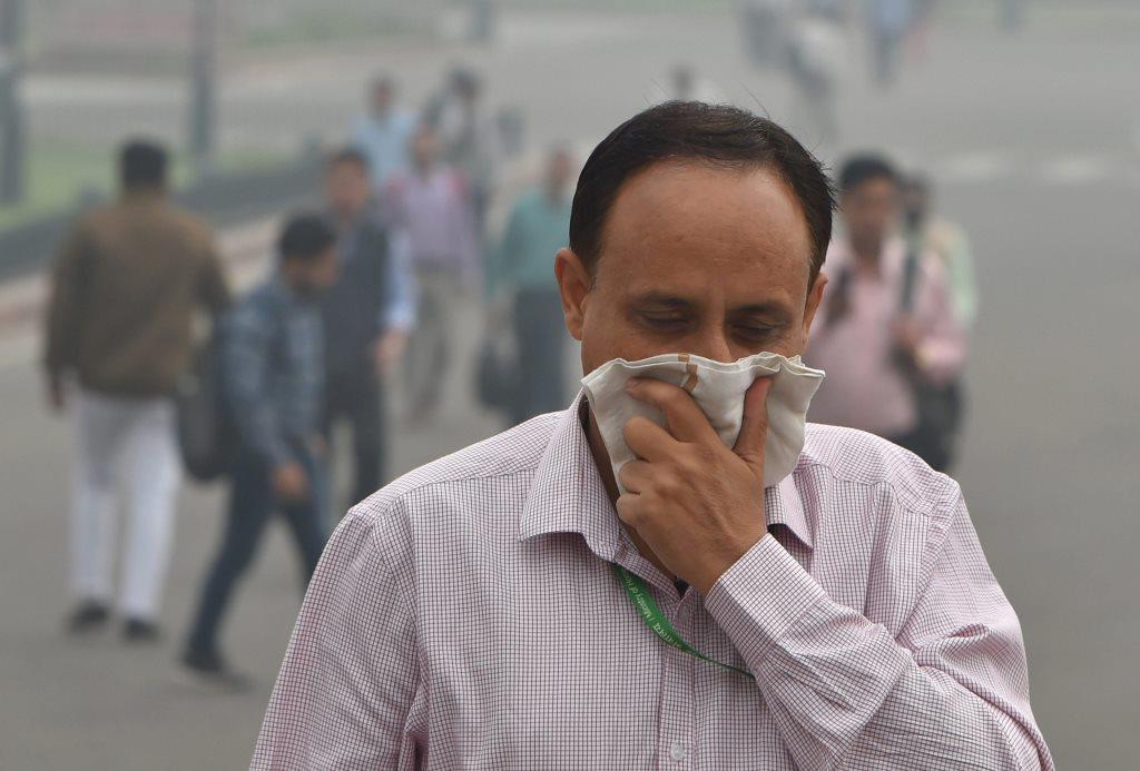 New Delhi: A pedestrian covers his face with a handkerchief for protection against air pollution, in New Delhi, Tuesday, Nov. 13, 2018. A thick haze engulfed the national capital today as the air quality remained in the 'severe' category and authorities expressed concern that light rainfall the city may worsen the pollution levels. (PTI Photo/Shahbaz Khan)(PTI11_13_2018_000025)