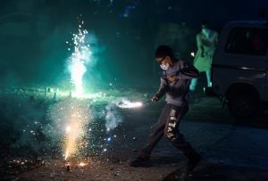 New Delhi: A boy wearing pollution mask burns crackers during Diwali celebrations, in New Delhi, Wednesday, Nov. 07, 2018. According to the officials, Delhi recorded its worst air quality of the year the morning after Diwali as the pollution level entered 'severe-plus emergency' category due to the rampant bursting of toxic firecrackers. (PTI Photo/Ravi Choudhary)(PTI11_8_2018_000023B)