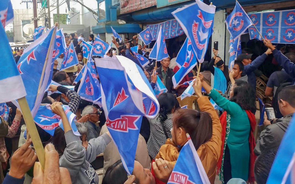 Aizawl: Mizo National Front (MNF) workers hold their party flag as they celebrate the party's victory in the states Assembly elections, at Party  head office, in Aizawl, Tuesday, Dec. 11, 2018. (PTI Photo)(PTI12_11_2018_000203)