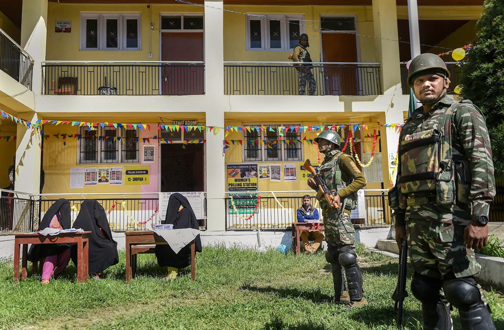 Shopian: Security personnel stand guard outside a polling station during the fifth phase of Lok Sabha elections, in Shopian district, Monday, May 6, 2019. (PTI Photo/S. Irfan)(PTI5_6_2019_000219B)