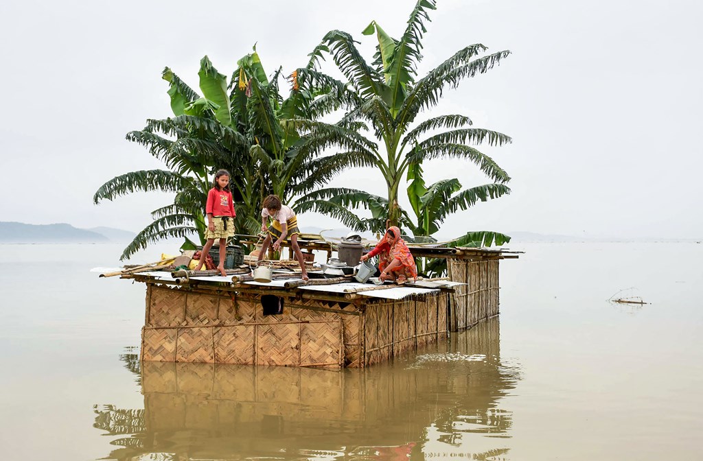Kamrup: A family marooned on the top of a hut in the flood-hit locality of Panikhaiti in Kamrup district of Assam, Monday, July 15, 2019. (PTI Photo) (PTI7_15_2019_000212B)