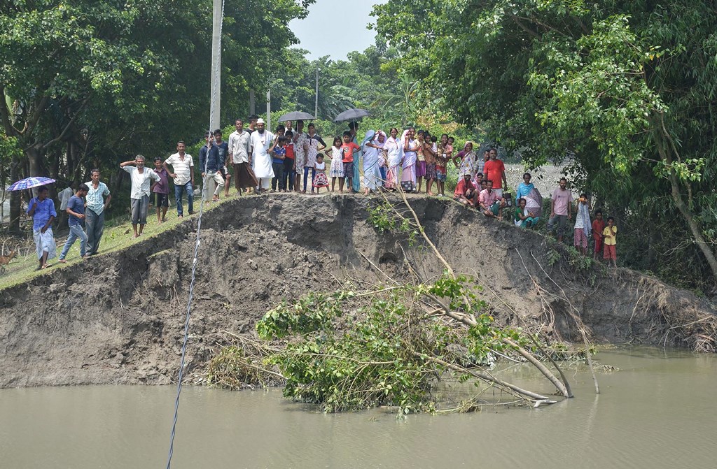 Darrang: Local people stand near an embankment which was breached by the swollen Brahmaputra river at a village, in Darrang district of Assam, Saturday, July 20, 2019. (PTI Photo)(PTI7_20_2019_000050B)