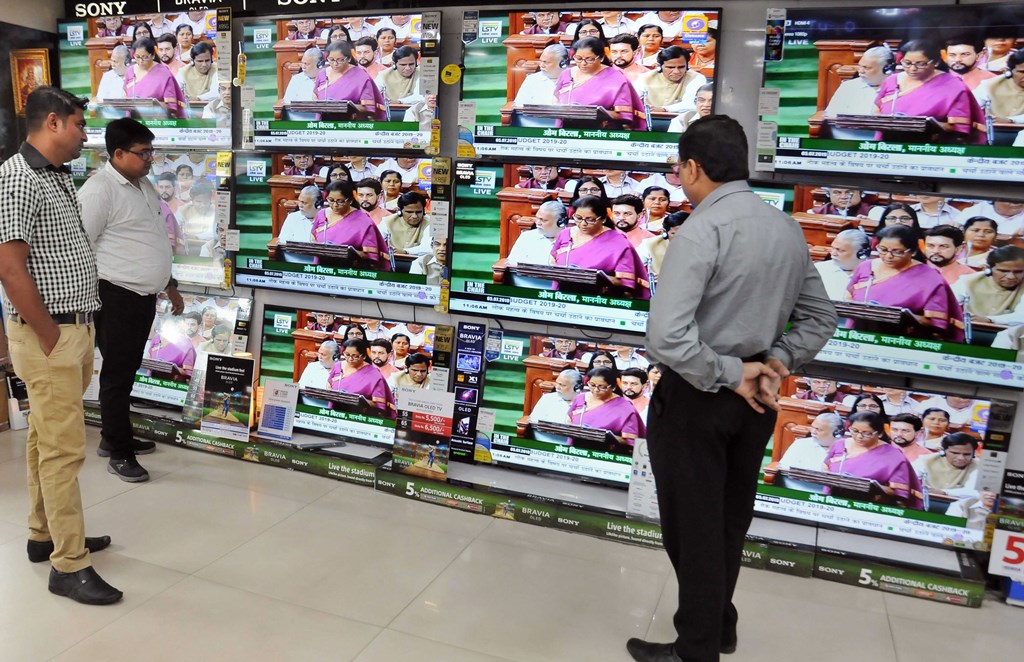 Kolkata: People watch Finance Minister Nirmala Sitharaman tabling the Union Budget 2019-20, on TV sets at a showroom in Kolkata, Friday, July 5, 2019. (PTI Photo) (PTI7_5_2019_000071B)
