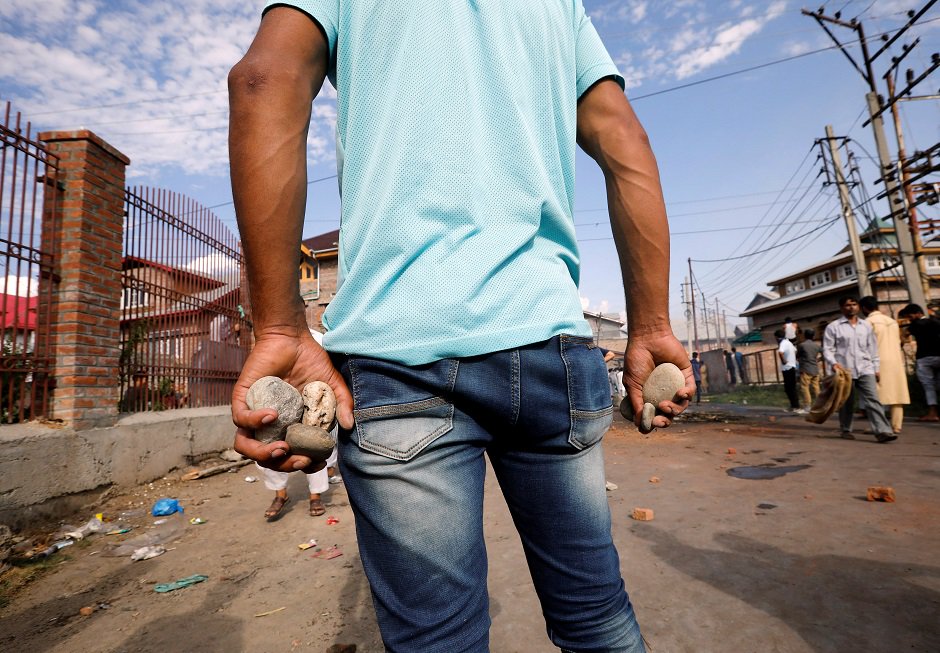 A Kashmiri man holds stones during clashes with Indian security forces, after scrapping of the special constitutional status for Kashmir by the Indian government, in Srinagar, August 23, 2019. REUTERS/Adnan Abidi 