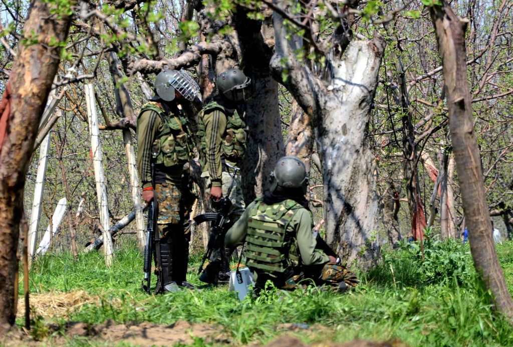 Army soldier take position behind trees during a gun battle between security forces and militants in Shopian, of South Kashmir on Sunday. Photo: PTI/S. Irfan/File