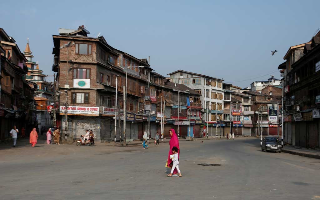 Residents cross a street during restrictions in Srinagar. (Photo:Reuters)