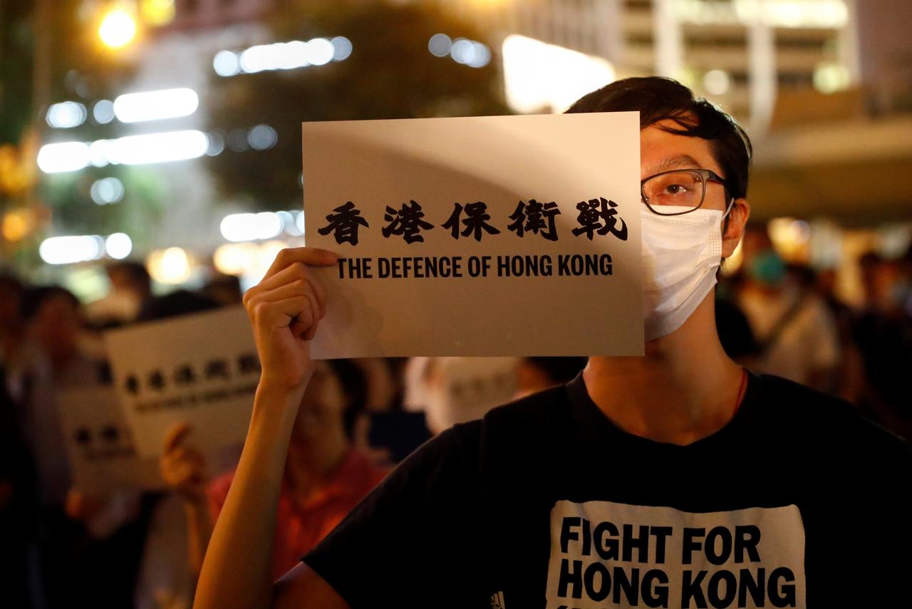 A man covers his eye with a placard as he attends a protest in Hong Kong, China August 30, 2019. REUTERS/Kai Pfaffenbach