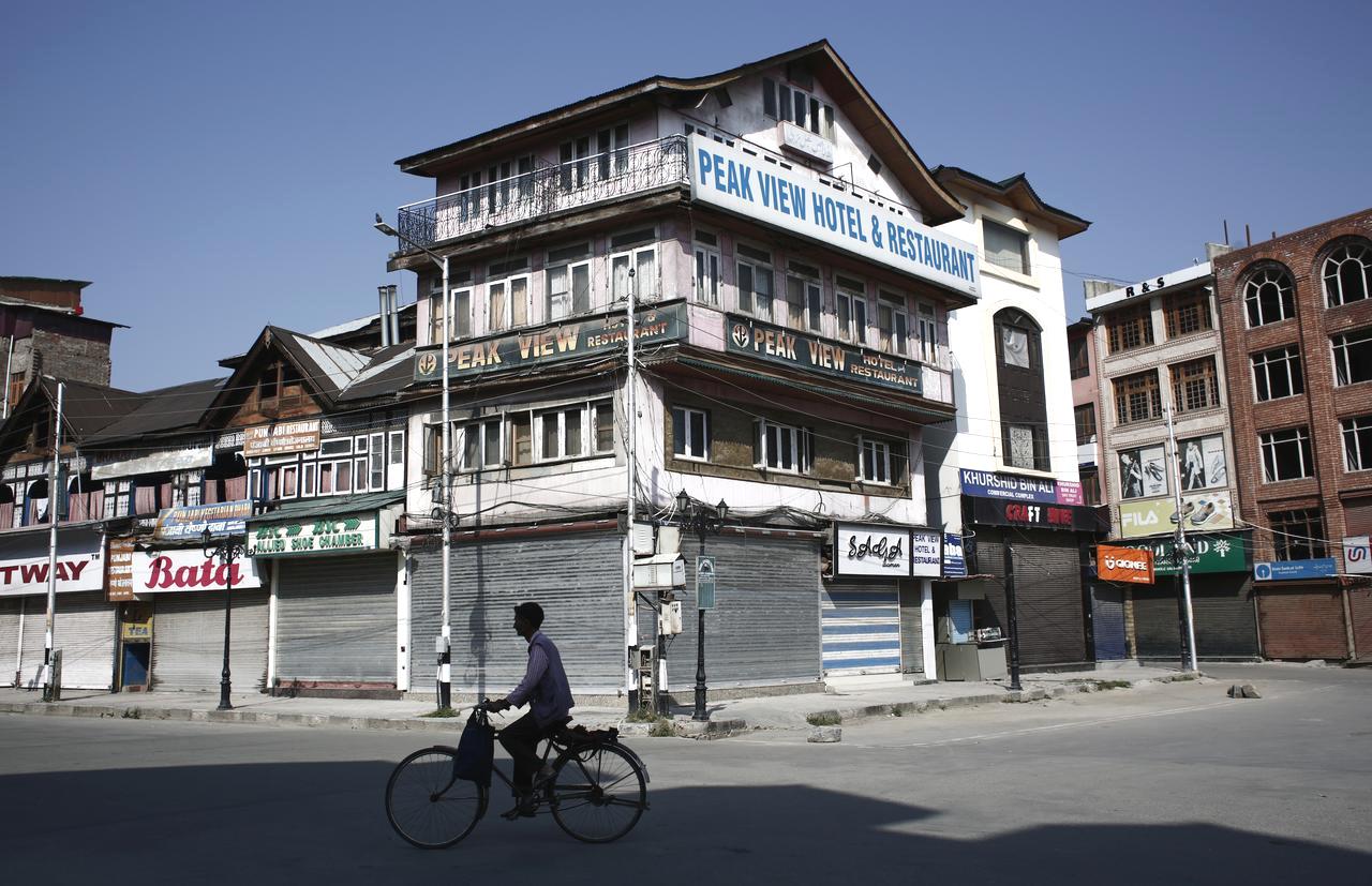 A man rides a bicycle past the closed shops and hotels during restrictions, after scrapping of the special constitutional status for Kashmir by the Indian government, in Srinagar, August 25, 2019. Picture taken August 25, 2019. REUTERS/Adnan Abidi