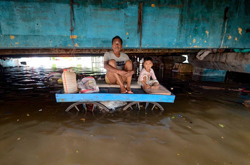 Patna: A flood-affected person sits with a child on a cart in an area affected by waterlogging following heavy monsoon rainfall, in Patna, Monday, Sept. 30, 2019. (PTI Photo) (PTI9_30_2019_000226B)
