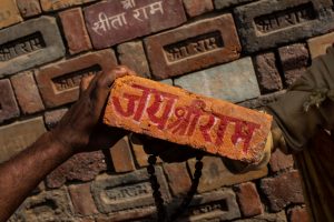 Ayodhya: FILE - In this Sunday, Nov. 25, 2018 photo, a man holds a brick reading "Jai Shree Ram" (Victory to Lord Ram) as bricks of the old Babri Mosque are piled up in Ayodhya, in the central Indian state of Uttar Pradesh. State-run broadcaster on Saturday, Nov. 9, 2019, said top court rules for disputed temple-mosque land for Hindus with alternate land to Muslims. Authorities increased security in Ayodhya, 550 kilometers (350 miles) east of New Delhi, and deployed more than 5,000 paramilitary forces to prevent any attacks by Hindu activists on Muslims, who comprise 6% of the town's more than 55,500 people. AP/PTI(AP11_9_2019_000038B)