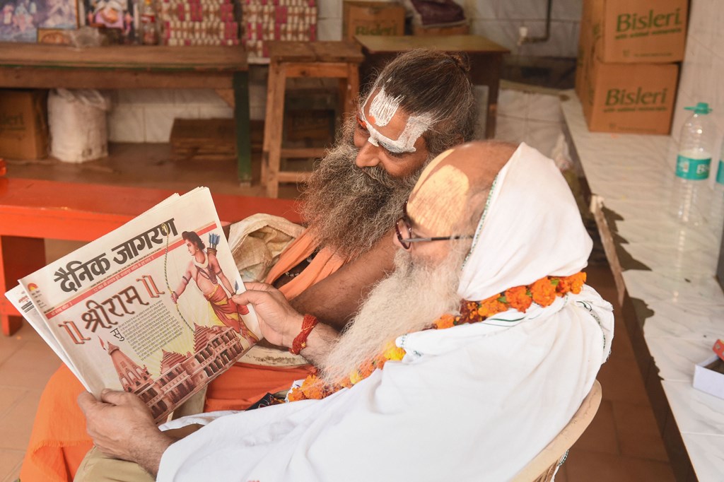 Ayodhya: Sadhus read newspaper fronted with headlines on Ayodhya case verdict, in Ayodhya, Sunday, Nov. 10, 2019. The Supreme Court in a historic verdict on Saturday, Nov. 9, 2019, backed the construction of a Ram temple by a trust at the disputed site in Ayodhya and ruled that an alternative five-acre plot must be found for a mosque in the Hindu holy town. (PTI Photo/Nand Kumar) -(PTI11_10_2019_000051B)