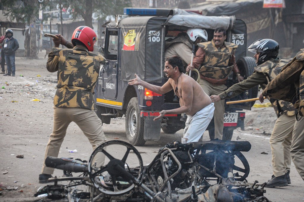 Kanpur: Police personnel hits a civilian during their protest against the Citizenship (Amendment) Act that turned violent, at Babu Purwa in Kanpur, Friday, Dec. 20, 2019. (PTI Photo) (PTI12_20_2019_000262B)