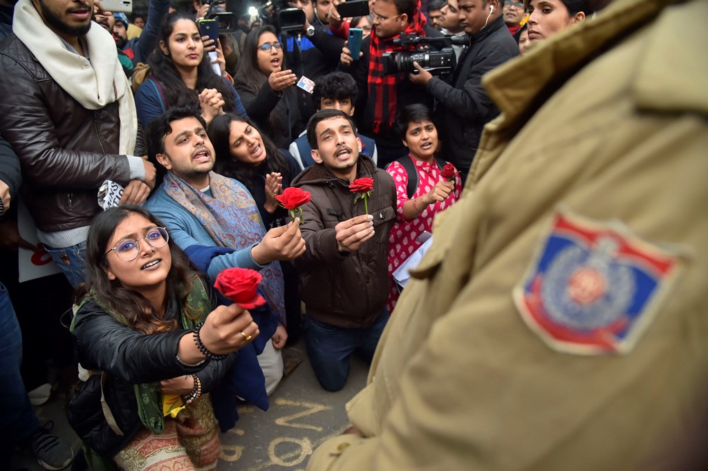 New Delhi: Protestors offer roses to police personnel during a demonstration against the Citizenship (Amendment) Act, at Mandi House, in New Delhi, Thursday, Dec. 19, 2019. (PTI Photo/Ravi Choudhary)(PTI12_19_2019_000172B)