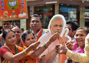 Hubballi: BJP supporters offer sweets to a cut-out of Prime Minister Narendra Modi after the party won in 12 out of 15 assembly constituencies of Karnataka securing the position of Yediyurappa-led BJP government in the state, in Hubballi, Monday, Dec. 9, 2019. (PTI Photo) (PTI12_9_2019_000091B)