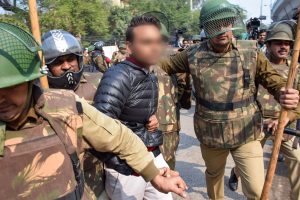New Delhi: Police detain an unidentified person (face blurred as his being an adult could not be ascertained), after he allegedly brandished a gun and opened fire towards students protesting against the Citizenship Amendment Act, near Jamia Millia Islamia University, in New Delhi, Thursday, Jan. 30, 2020. (PTI Photo) (PTI1_30_2020_000178B) *** Local Caption ***