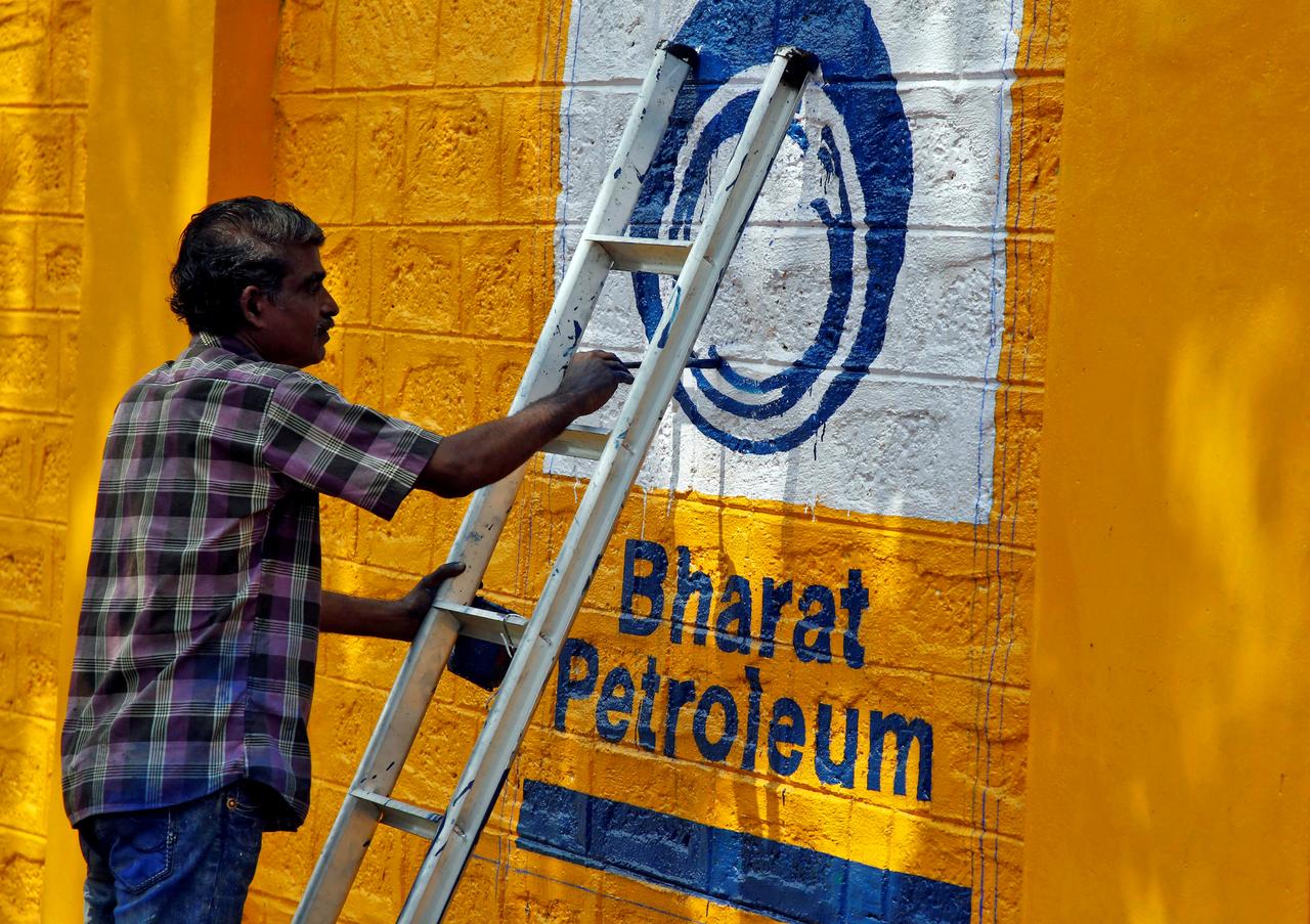 A man paints the logo of oil refiner Bharat Petroleum Corp (BPCL) on a wall on the outskirts of Kochi, India, November 21, 2019. REUTERS/Sivaram V/File Photo