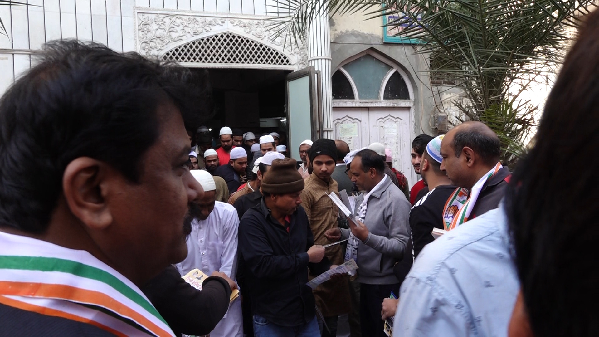 मंडावली के एक मस्जिद में आप और कांग्रेस कार्यकर्ता पर्चा बांटते हुए (फोटो: द वायर स्टाफ)