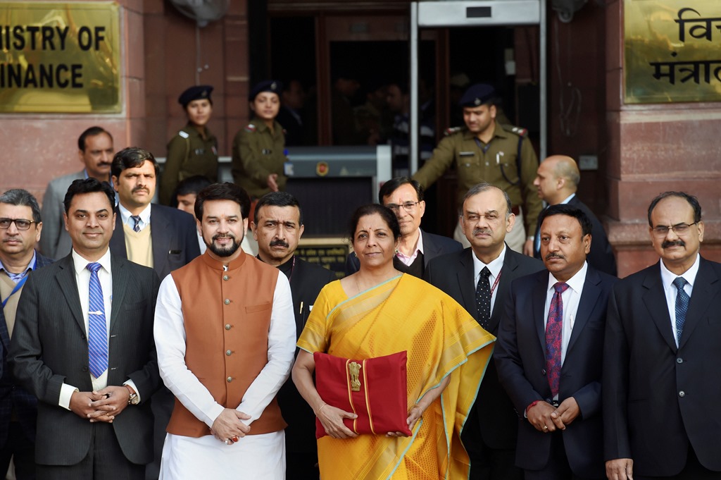 New Delhi: Union Finance Minister Nirmala Sitharaman, holding a folder containing the Union Budget documents, poses for photographers along with her deputy Anurag Thakur and a team of officials, outside the Ministry of Finance, North Block in New Delhi, Saturday, Feb. 1, 2020. (PTI Photo/Kamal Singh) (PTI2_1_2020_000013B)