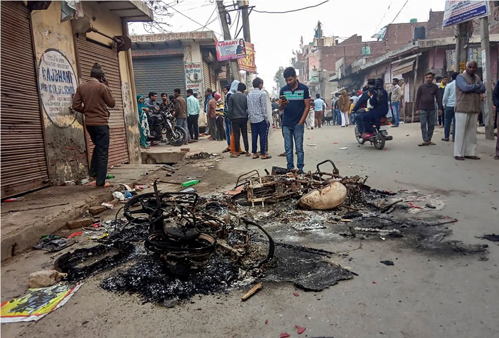 **EDS: BEST QUALITY AVAILABLE**New Delhi: Passersby look at the charred remains of vehicles which were set ablaze by rioters during clashes over the new citizenship law, at Mustafabad area of East Delhi, Tuesday, Feb. 25, 2020. (PTI Photo/ Sachin Saini)(PTI2_25_2020_000093B)
