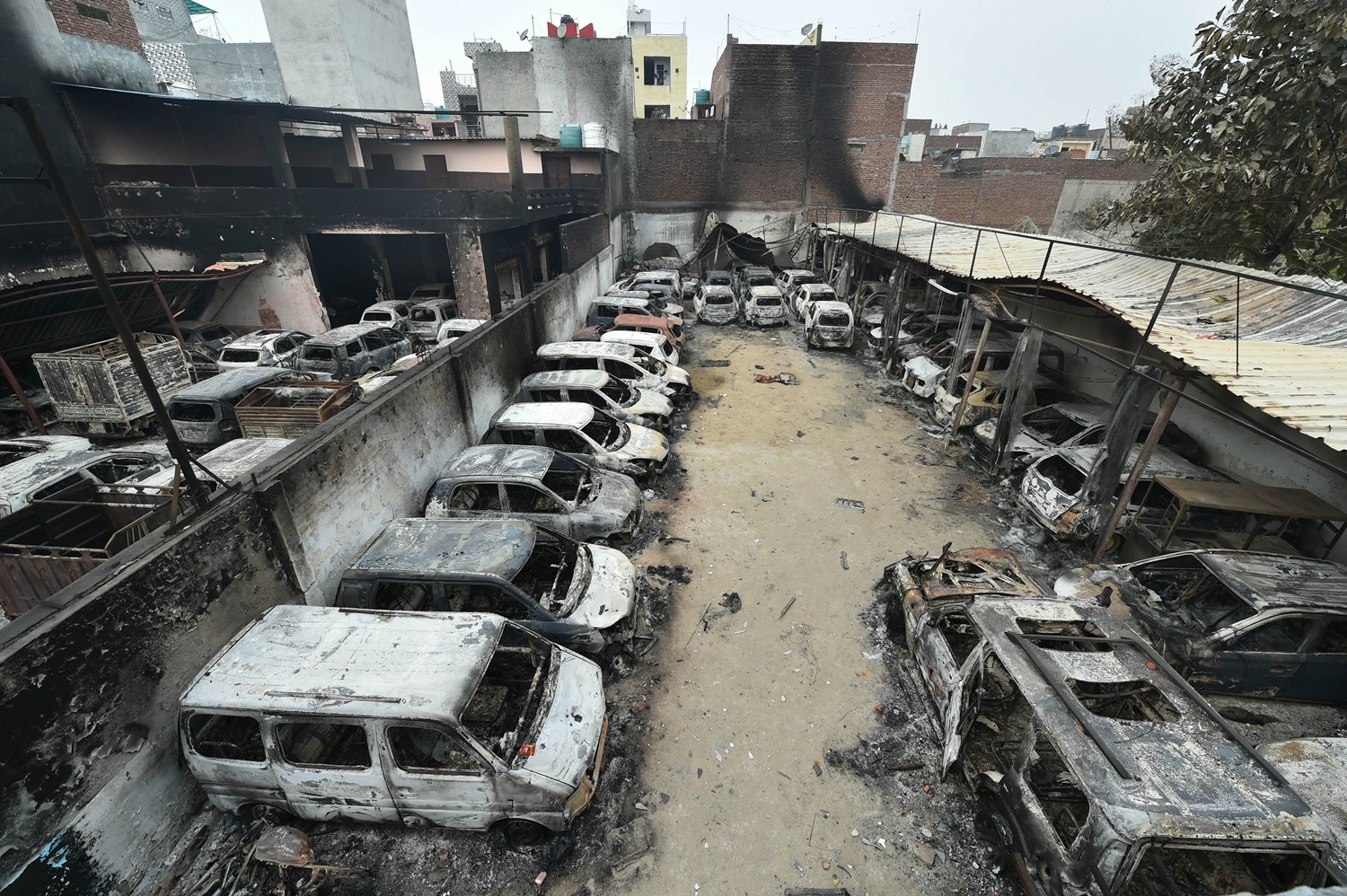 New Delhi: Charred remains of vehicles set ablaze by rioters during communal violence over the amended citizenship law, at Shivpuri area of north east Delhi, Thursday, Feb. 27, 2020. (PTI Photo/Arun Sharma)(PTI2_27_2020_000030B)