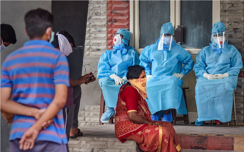 Vijayawada: Workers wearing protective suits sit outside an isolation ward at Government General Hospital during the nationwide lockdown, imposed in wake of the coronavirus pandemic, in Vijayawada, Monday, April 20, 2020. (PTI Photo)(PTI20-04-2020_000165B)