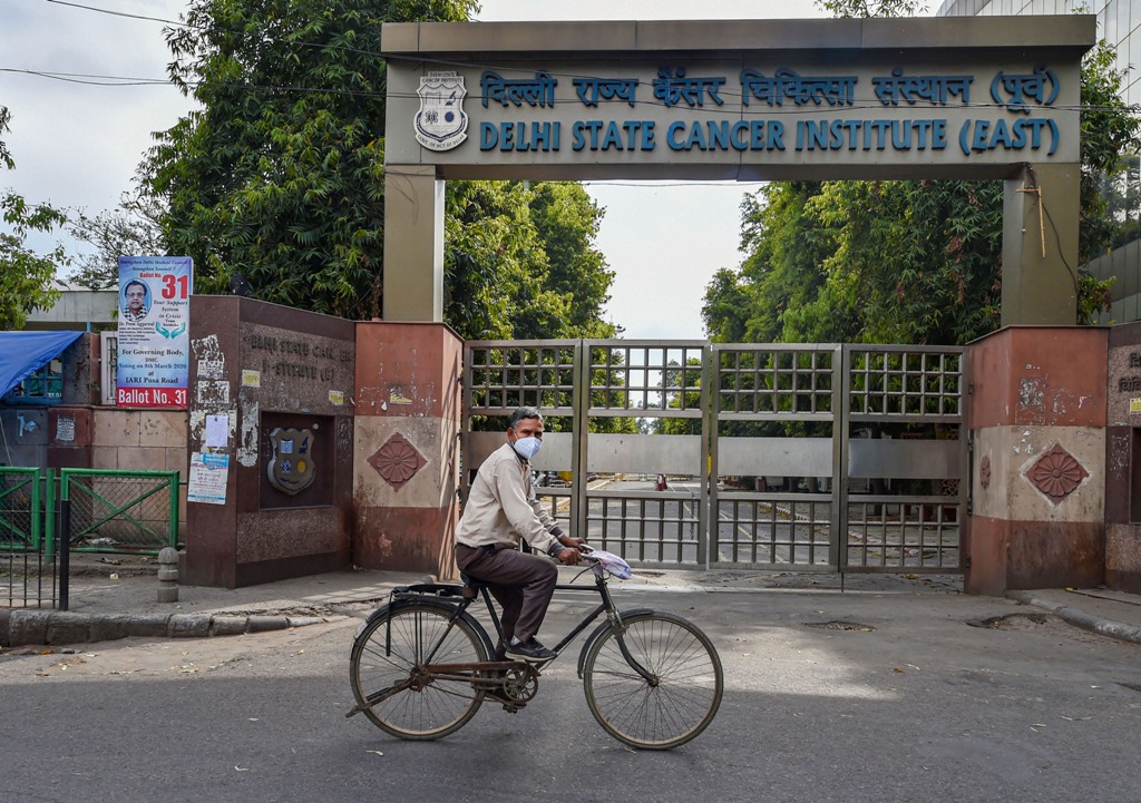New Delhi: A cyclist wearing a mask rides past the Delhi State Cancer Institute (DSCI)during the nationwide lockdown, imposed as a preventive measure against the coronavirus pandemic, in East Delhi, Monday, April 20, 2020. (PTI Photo/Manvender Vashist) (PTI20-04-2020_000281B)