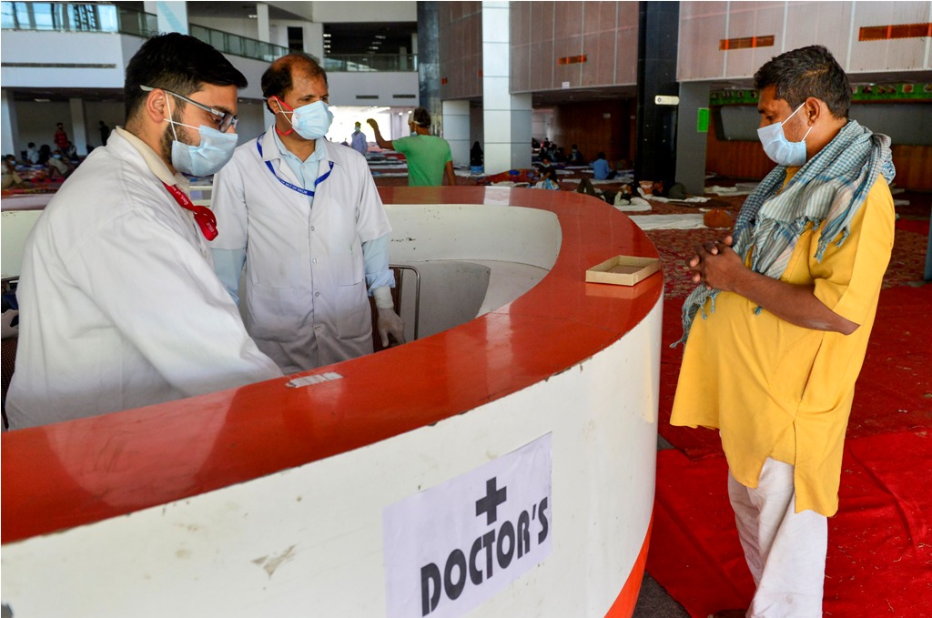 New Delhi: Doctors talk to a patient at a sports complex converted into a shelter during a nationwide lockdown in the wake of coronavirus pandemic, in New Delhi Friday, April 3, 2020. (PTI Photo/Kamal Kishore)(PTI03-04-2020 000098B)