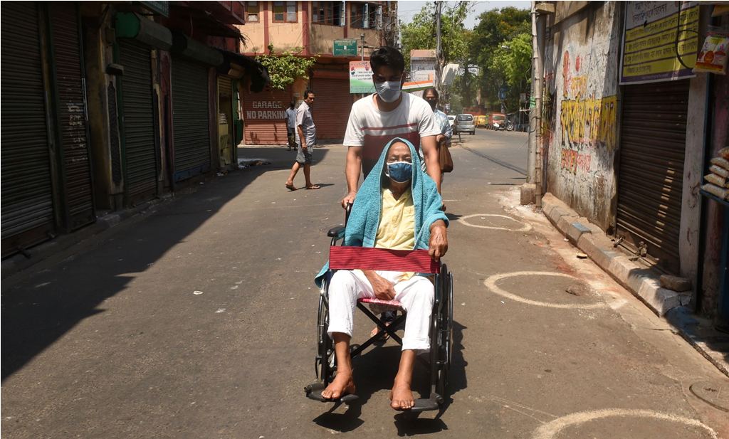 Kolkata: A man helps a physically challenged person during the nationwide lockdown to curb the spread of coronavirus, in Kolkata, Friday, April 10, 2020. (PTI Photo/Ashok Bhaumik)(PTI10-04-2020 000079B)