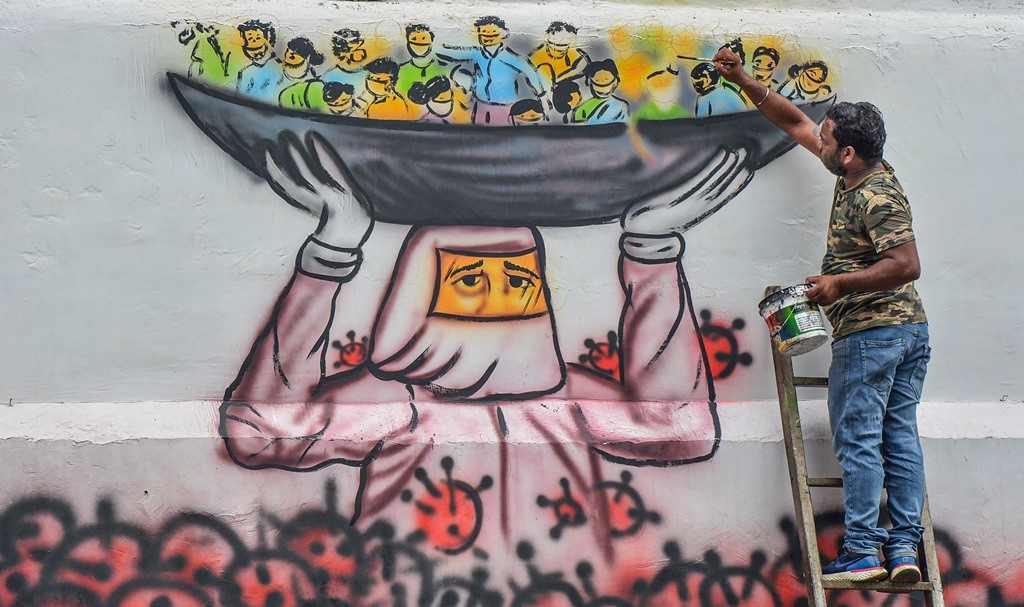 Guwahati: An artist paints a mural on a wall depicting a doctor saving people's lives from deadly coronavirus, during the ongoing nationwide lockdown, in Guwahati, Tuesday, May 19, 2020. (PTI Photo)(PTI19-05-2020_000202B)