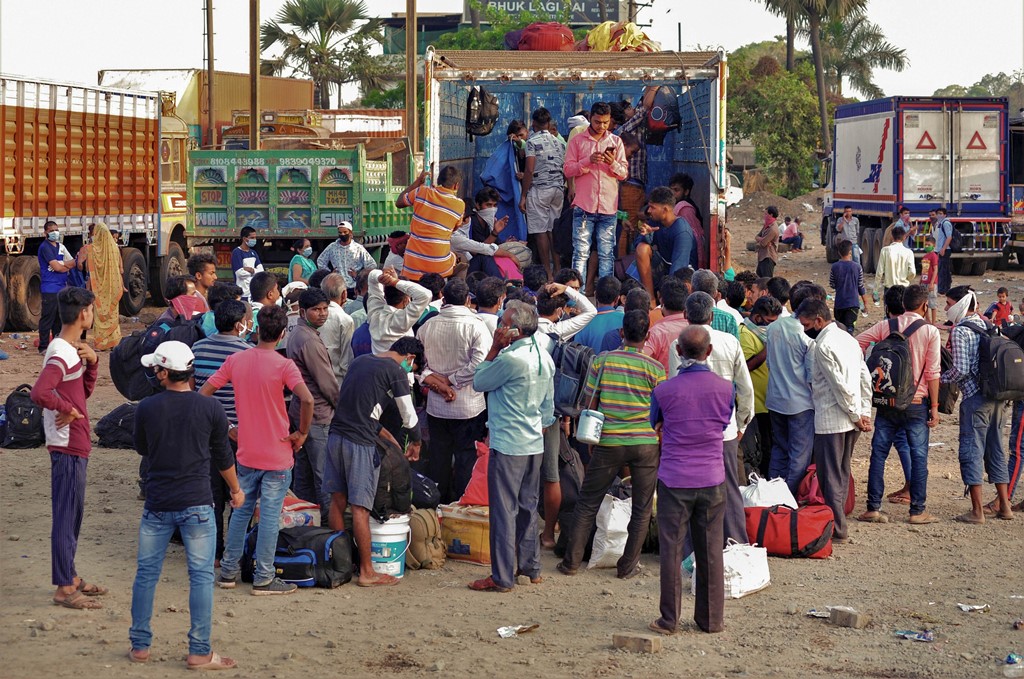 Mumbai: Migrants board a truck to travel to their native places in UP during the ongoing COVID-19 nationwide lockdown, in Mumbai, Wednesday, May 13, 2020. (PTI Photo) (PTI13-05-2020_000066B)