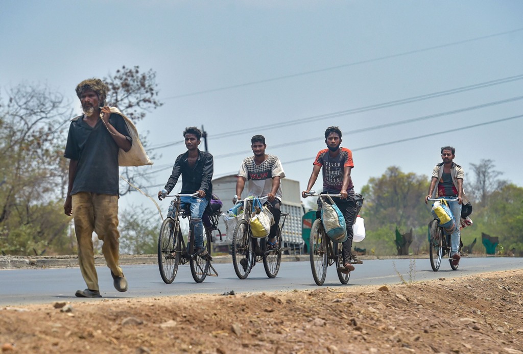 Thane: Migrants with their belongings ride on bicycles as they move towards their native places on the Mumbai-Nashik highway during the nationwide lockdown, in wake of the coronavirus pandemic, in Thane, Friday, May 1, 2020. (PTI Photo/Mitesh Bhuvad)(PTI01-05-2020_000219B) *** Local Caption *** 