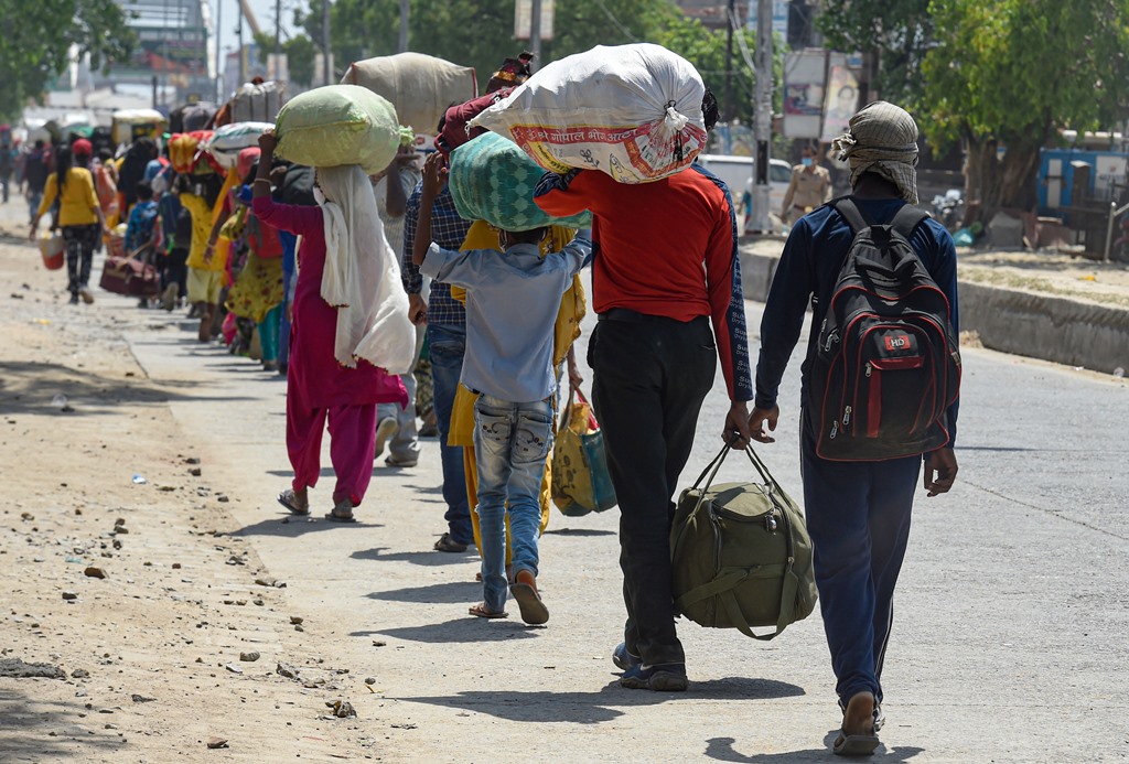 Dadri: Migrant workers wait in a queue while being lodged at a camp by the Uttar Pradesh government, during ongoing COVID-19 lockdown, at Dadri in Gautam Buddha Nagar district, Wednesday, May 20, 2020. (PTI Photo/Atul Yadav) (PTI20-05-2020 000206B)