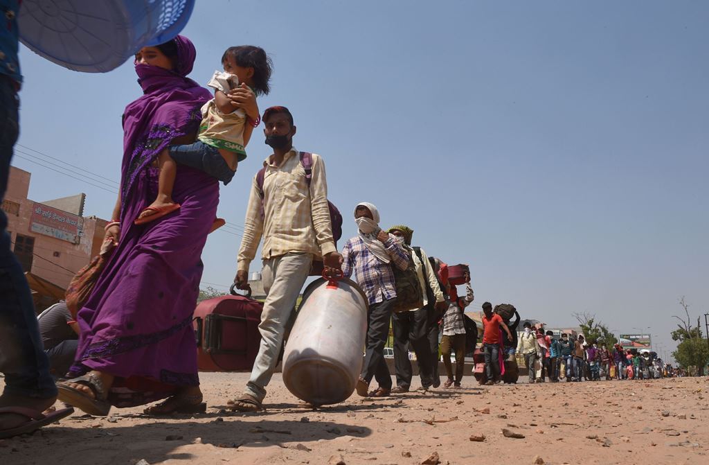 Dadri: Migrant workers wait in a queue while being lodged at a camp by the Uttar Pradesh government, during ongoing COVID-19 lockdown, at Dadri in Gautam Buddha Nagar district, Wednesday, May 20, 2020. (PTI Photo/Atul Yadav) (PTI20-05-2020_000214B)