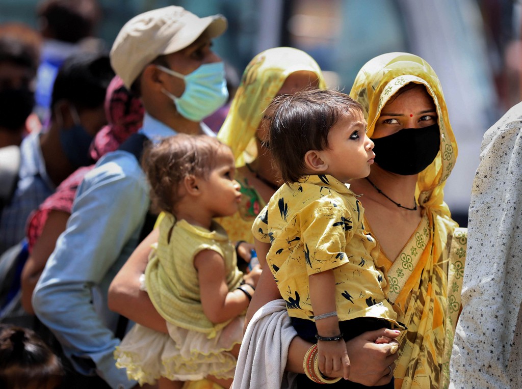 Prayagraj: Migrants wait to board buses to reach their native places after arriving via special train, during the ongoing COVID-19 lockdown, in Prayagraj, Tuesday, May 26, 2020. (PTI Photo) (PTI26-05-2020 000040B)