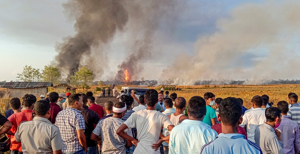 Tinsukia: Locals look on as smoke billows from a fire at Baghjan oil field, a week after a blowout, in Tinsukia district, Tuesday, June 9, 2020. A team from Singapore was called to assess the reason of the blowout yesterday. (PTI Photo)(PTI09-06-2020_000160B)