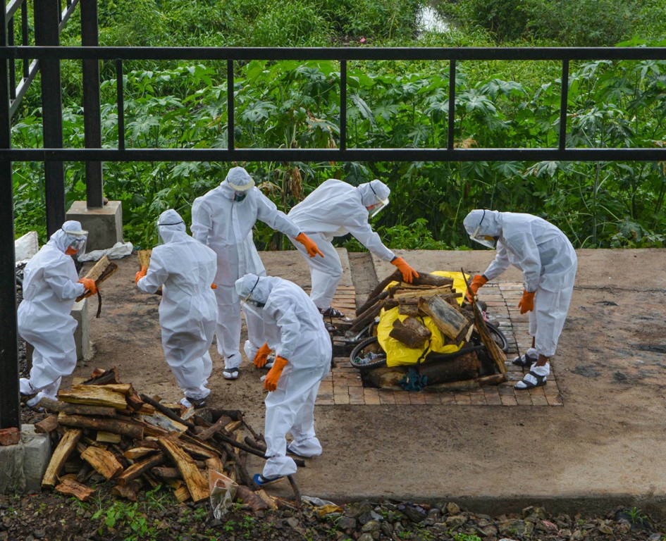 Karad: Municipal workers and family members wearing protective suits cremate the body of a person who died of COVID-19 at a crematorium, during the ongoing nationwide lockdown, in Karad, Friday, June 26, 2020. (PTI Photo)(PTI26-06-2020 000179B)